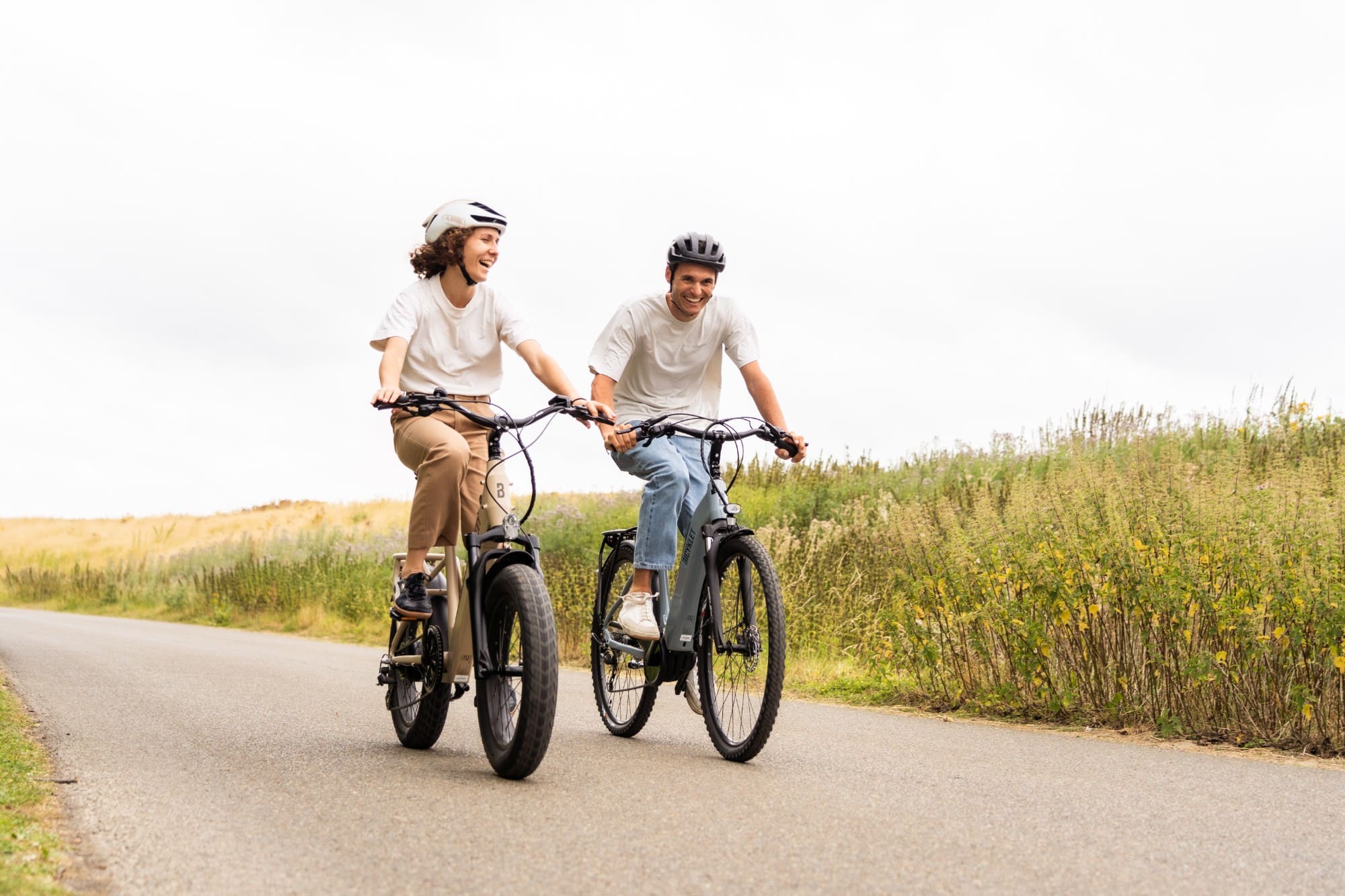 Deux collaborateurs à vélo sur une route de campagne